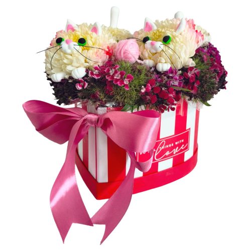 Escultura floral de gatitos blancos sobre base de mini claveles fucsias y follaje en box de corazón para entrega a domicilio